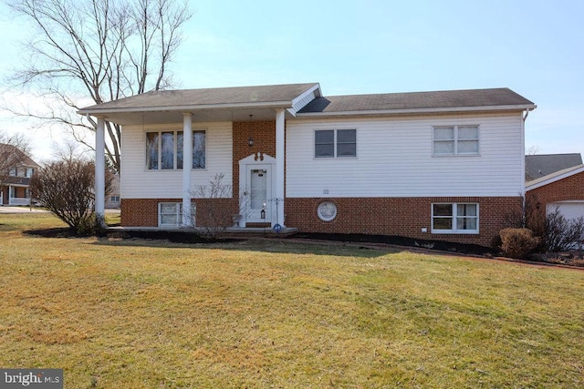 bi-level home featuring brick siding and a front lawn