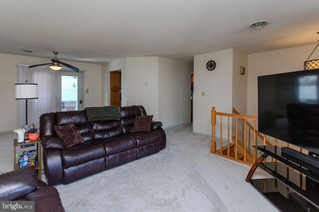 living room featuring baseboards, visible vents, a ceiling fan, and carpet