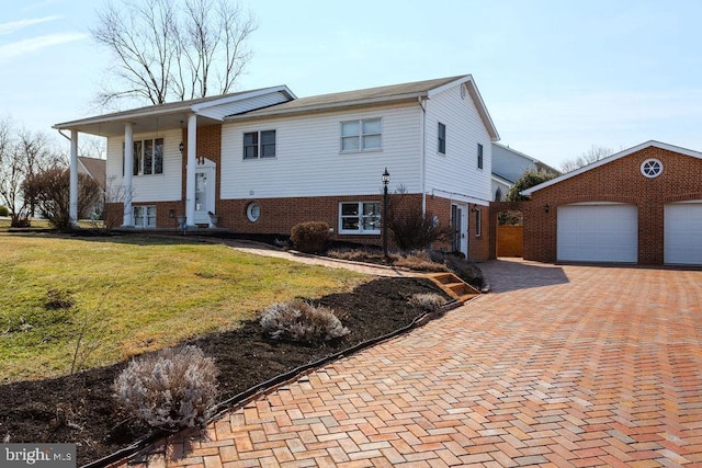 bi-level home featuring a garage, an outdoor structure, and a front lawn
