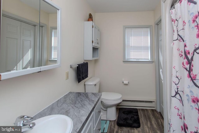 full bathroom with a wealth of natural light, baseboard heating, wood finished floors, and toilet