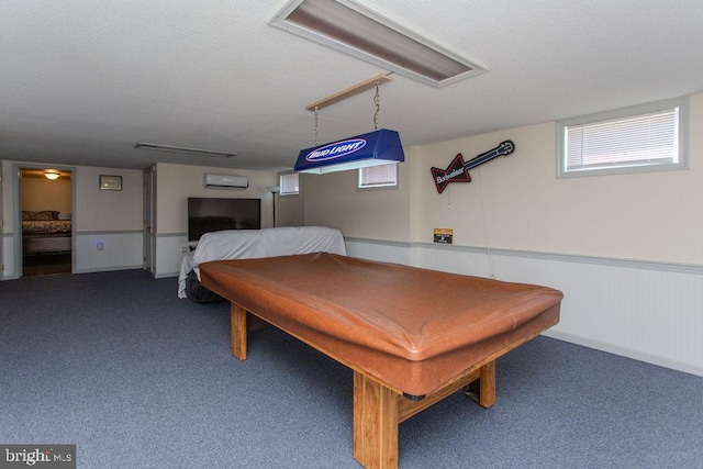 recreation room with a wainscoted wall, a textured ceiling, billiards, and carpet