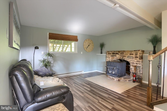 living area with baseboards, a baseboard radiator, a wood stove, and wood finished floors