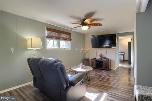 living room featuring baseboards, a ceiling fan, and wood finished floors
