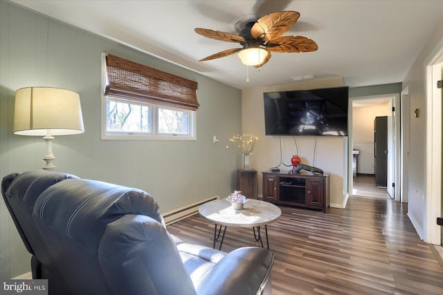 living room featuring a ceiling fan, a baseboard heating unit, and wood finished floors
