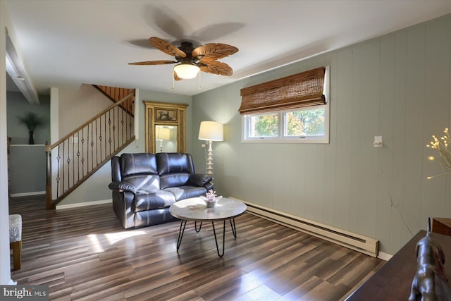 living area featuring stairs, ceiling fan, wood finished floors, and a baseboard radiator