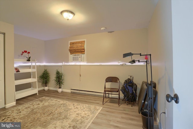 interior space with baseboards, wood finished floors, and cooling unit