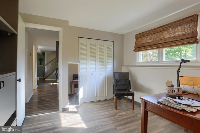 sitting room with baseboards, stairs, and wood finished floors