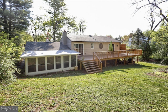 rear view of house with a wooden deck, a chimney, a sunroom, stairs, and a yard