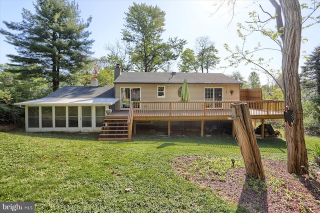 back of property featuring stairs, a wooden deck, a sunroom, a chimney, and a lawn