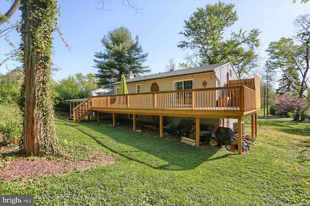 back of house with stairs, a wooden deck, and a yard