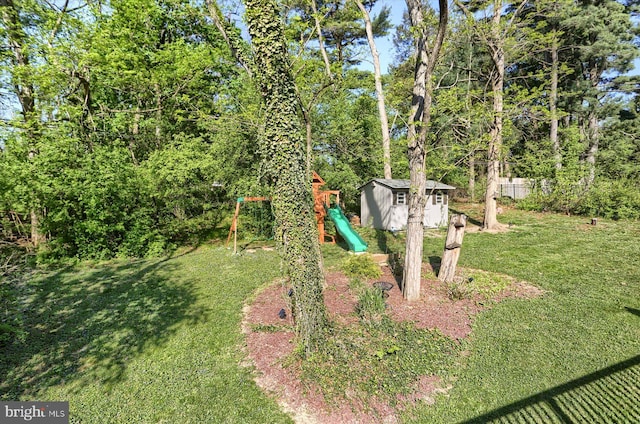 view of yard with a playground, an outdoor structure, and a shed