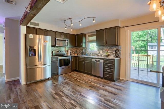 kitchen featuring visible vents, tasteful backsplash, a sink, dark wood finished floors, and stainless steel appliances