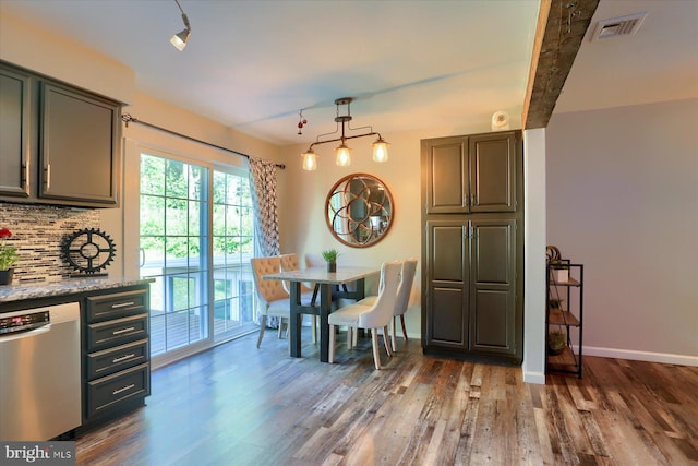 dining space with baseboards, visible vents, and dark wood finished floors