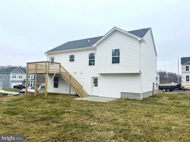 rear view of house featuring a lawn, stairs, and a deck