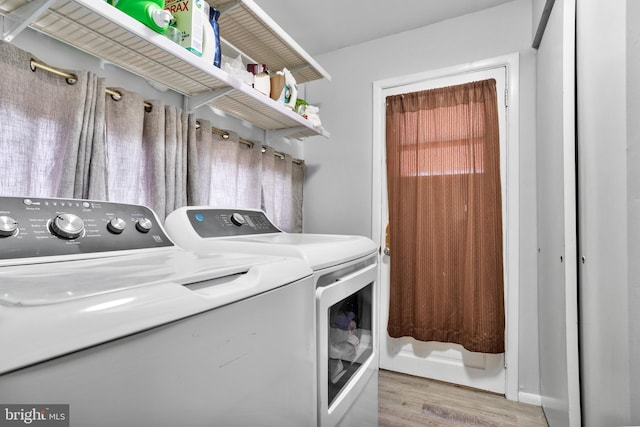 laundry area with light wood finished floors, laundry area, and independent washer and dryer