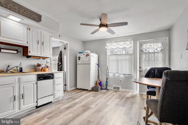 kitchen with visible vents, a ceiling fan, a sink, white appliances, and light wood-style floors