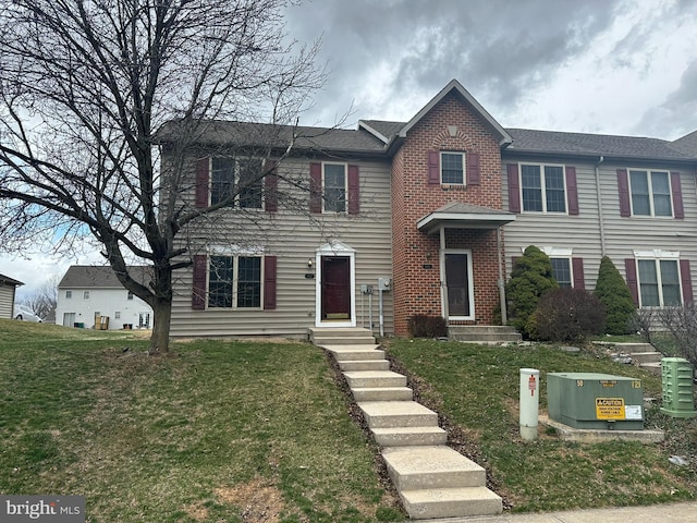 view of front of property with brick siding and a front lawn