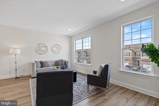 living area featuring recessed lighting, light wood-style flooring, and baseboards