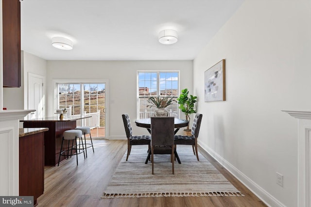 dining area featuring baseboards and light wood-style floors