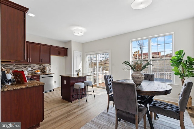 dining space featuring light wood-style flooring and baseboards