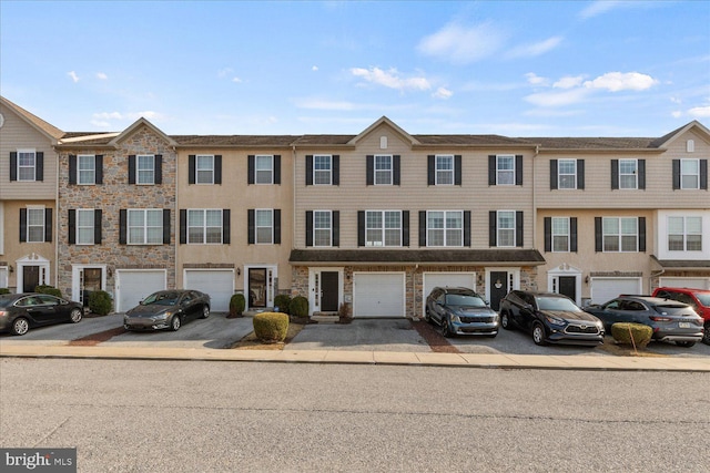 view of property featuring an attached garage and driveway