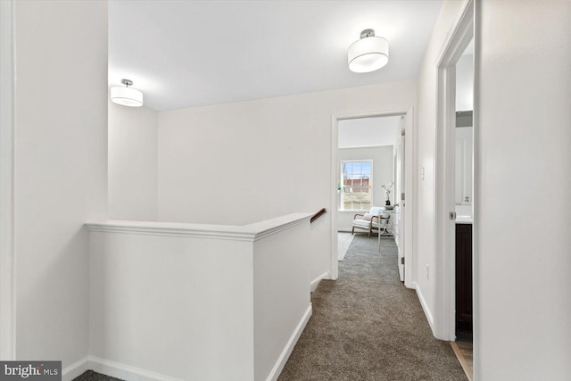 hallway with an upstairs landing, carpet flooring, and baseboards