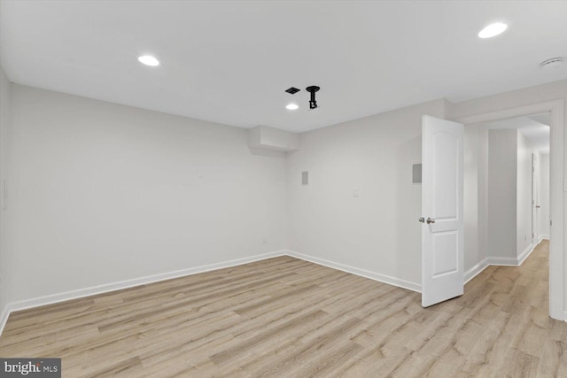 empty room featuring recessed lighting, baseboards, and light wood-style floors