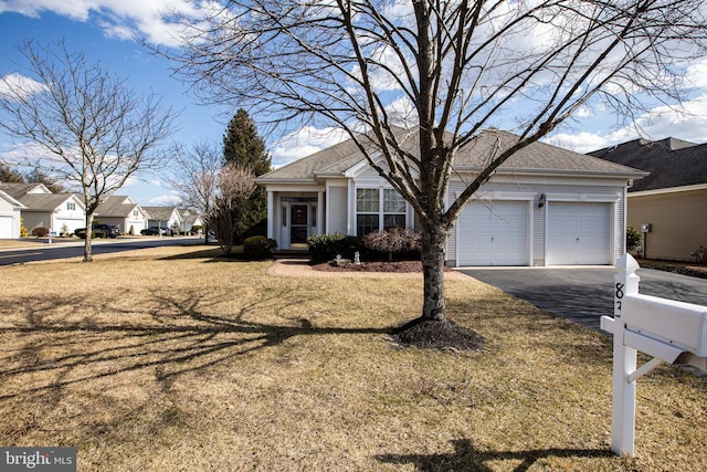 view of front of property featuring aphalt driveway, an attached garage, a front yard, and a shingled roof