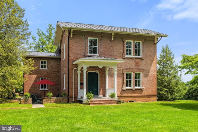 italianate home featuring a standing seam roof, brick siding, and metal roof