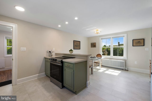 kitchen featuring electric stove, radiator, a peninsula, green cabinetry, and light countertops