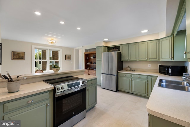 kitchen featuring appliances with stainless steel finishes, green cabinets, a sink, light countertops, and recessed lighting