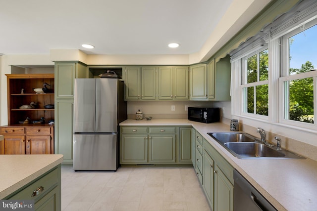 kitchen with green cabinets, appliances with stainless steel finishes, a sink, and recessed lighting