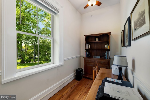 office area featuring hardwood / wood-style floors, a ceiling fan, and baseboards