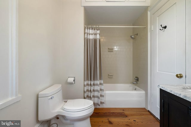 bathroom featuring toilet, vanity, wood finished floors, and shower / bathtub combination with curtain