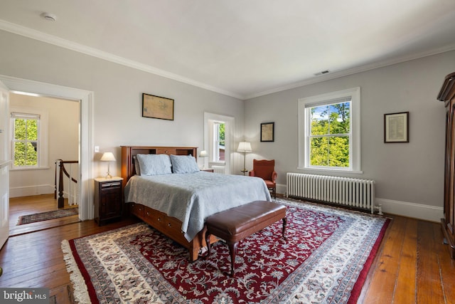 bedroom featuring radiator heating unit, hardwood / wood-style flooring, baseboards, and ornamental molding