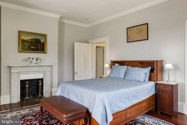 bedroom with dark wood-style flooring, crown molding, and a fireplace