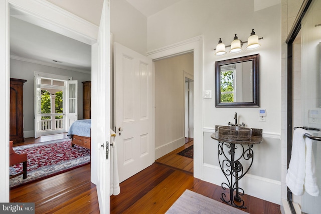 foyer with hardwood / wood-style floors, ornamental molding, and baseboards