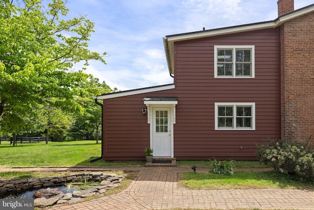 back of house featuring an outdoor fire pit and a chimney