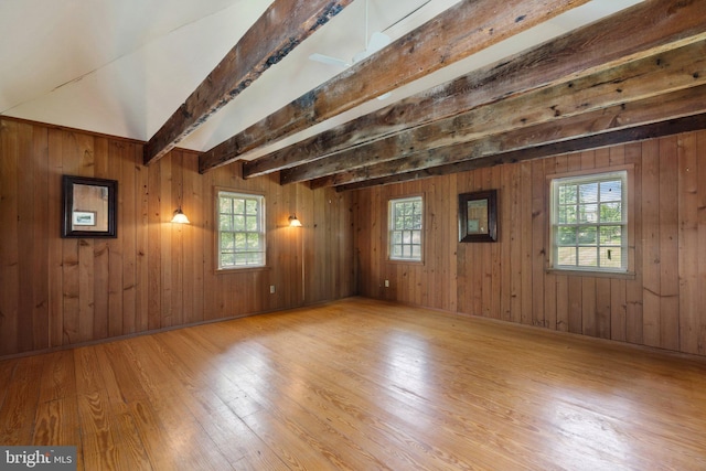 unfurnished room featuring hardwood / wood-style flooring, beamed ceiling, and wood walls