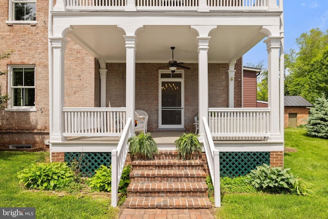entrance to property featuring covered porch, brick siding, ceiling fan, and a balcony
