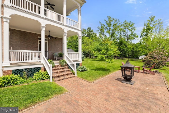 view of patio / terrace featuring a ceiling fan, a balcony, a porch, and an outdoor fire pit