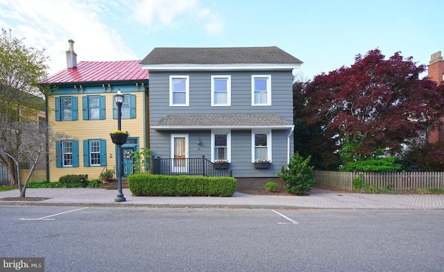 multi unit property featuring fence and a shingled roof