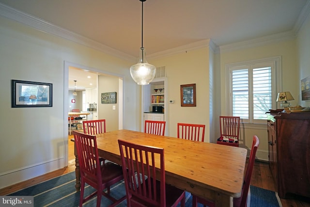 dining area featuring crown molding, baseboards, dark wood-style floors, and visible vents