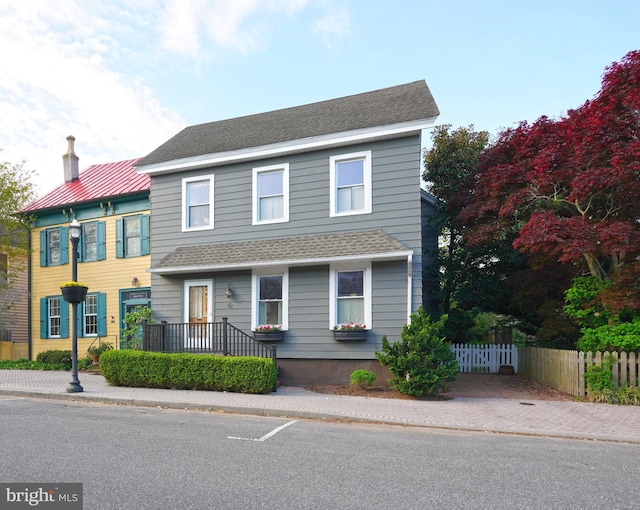 view of front of house with fence and a shingled roof