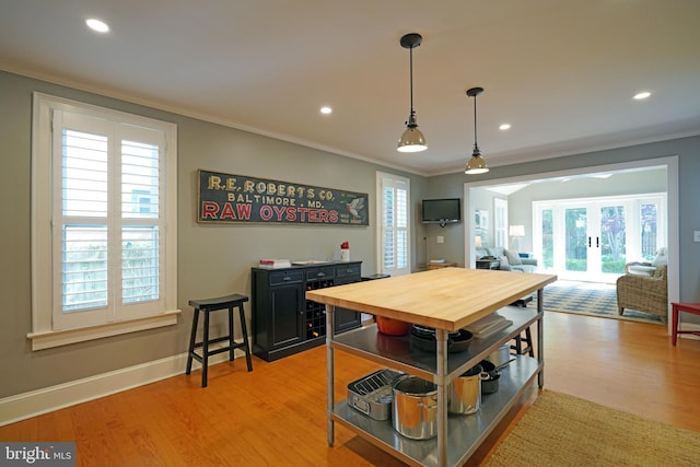 dining space featuring crown molding, french doors, and light wood-style floors