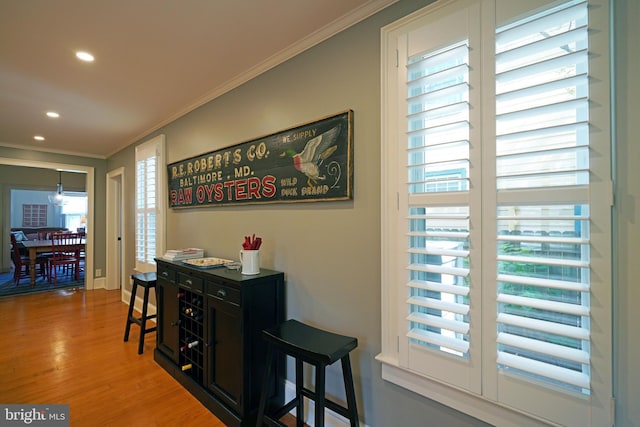corridor featuring recessed lighting, ornamental molding, and wood finished floors