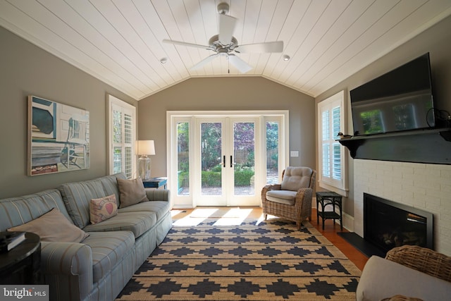 living room featuring a fireplace, french doors, a ceiling fan, wood finished floors, and lofted ceiling