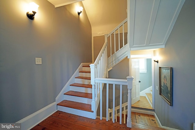 staircase featuring baseboards and hardwood / wood-style floors
