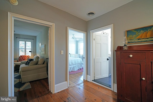 interior space with baseboards, light wood finished floors, and visible vents