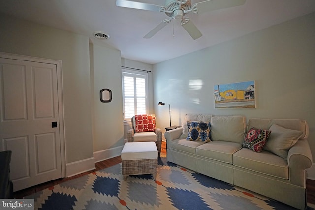 living room featuring baseboards, a ceiling fan, wood finished floors, and visible vents